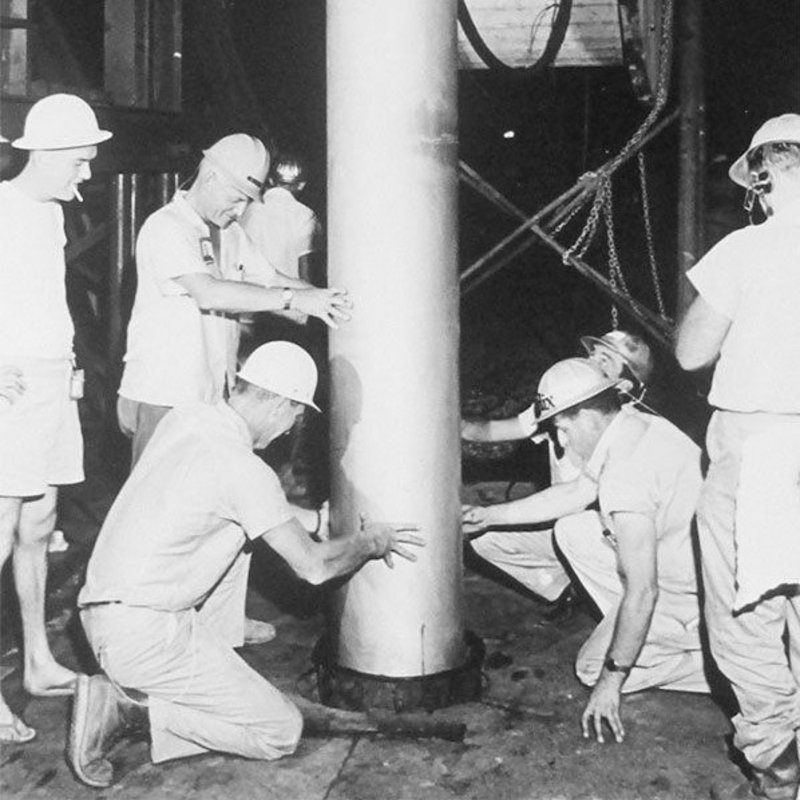 Arbeiter senken die 5,3-Kilotonnen-Bombe, die beim Salmon-Test verwendet wurde, in den Boden